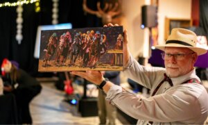 Man in derby hats holds colorful painting of a horse race.